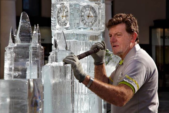 Man carving Houses of Parliament ice model