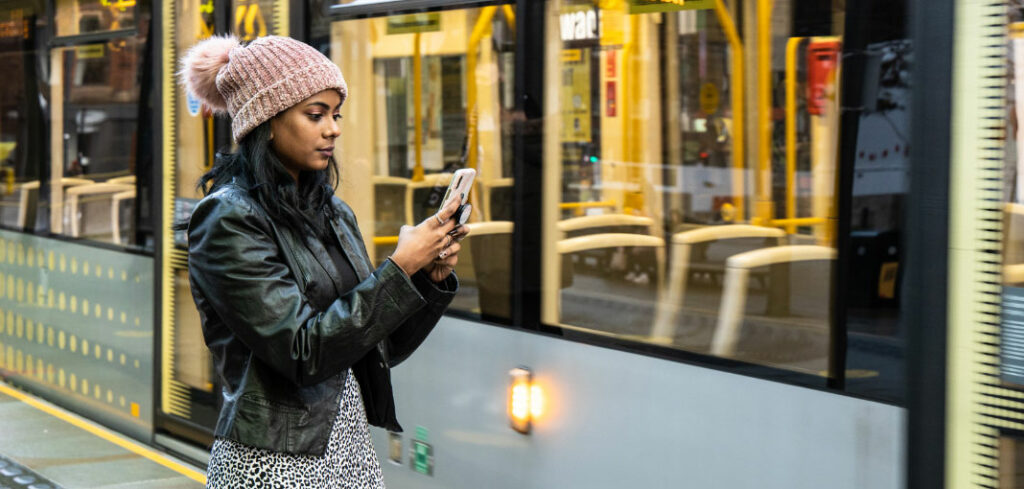 Girl using smartphone on tram platform