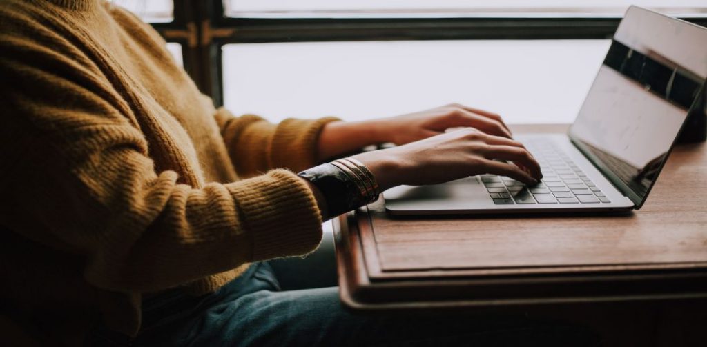 Close up of person's hands typing on a keyboard