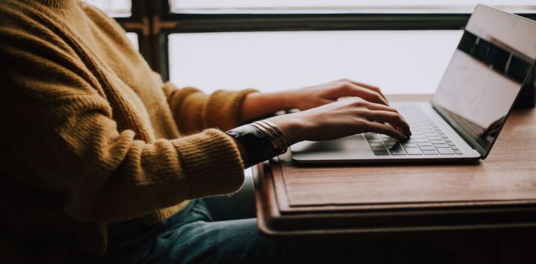 Close up of person's hands typing on a keyboard