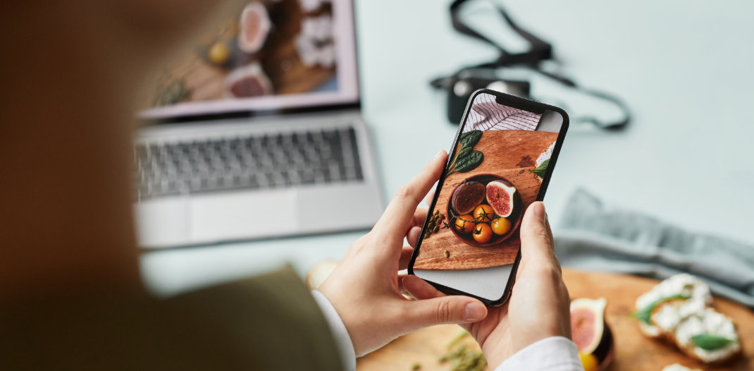 Lady taking a photo of food for her blog article before adding meta data to it