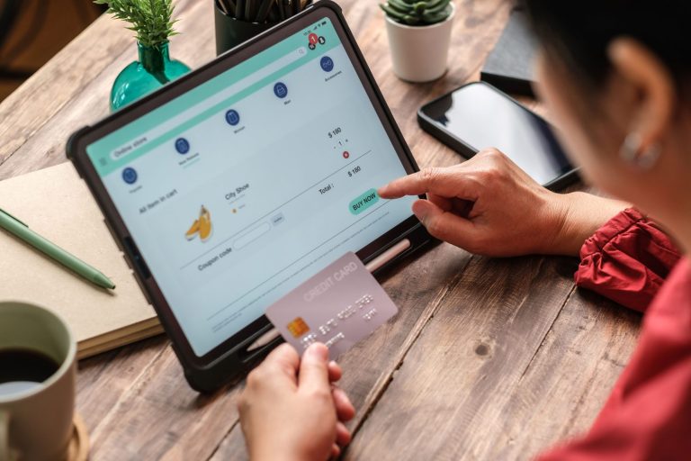 Woman online shopping on a tablet with her credit card in hand